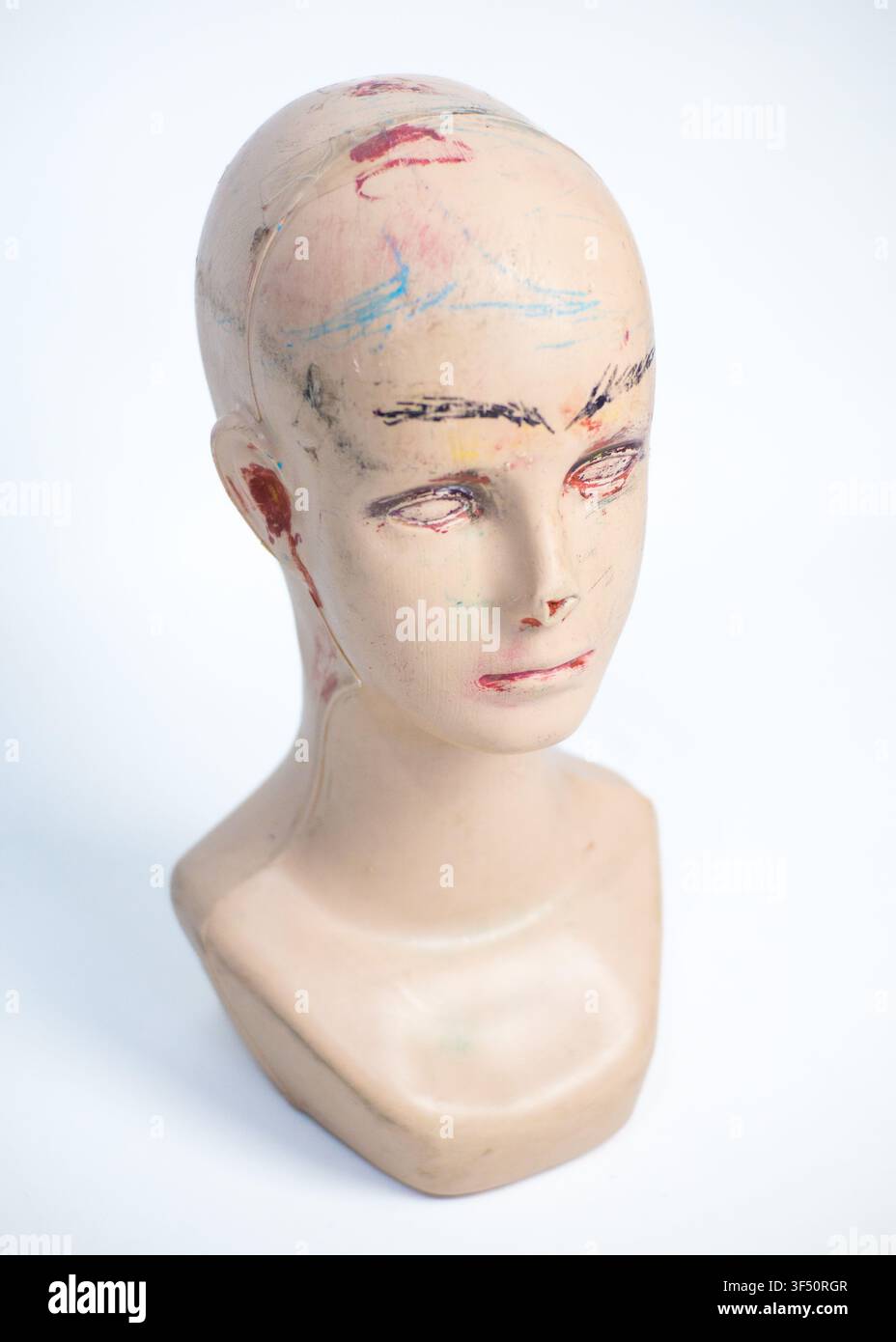 Tête de mannequin vintage usée avec gribouillis sur fond blanc Banque D'Images
