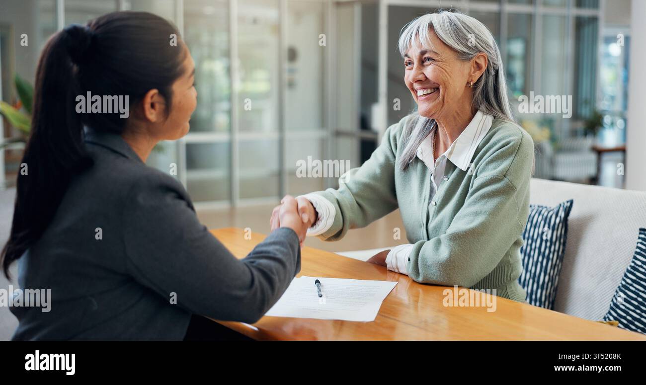 Sourire, vieille femme et poignée de main à la maison avec un conseiller, transaction immobilière et contrat d'achat. Personne âgée, serrant la main et merci pour Banque D'Images