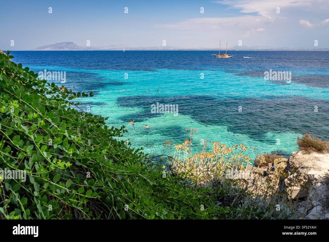 Vacanciers nageant et plongeant dans les belles eaux turquoise de la plage de Favignana en Sicile Banque D'Images