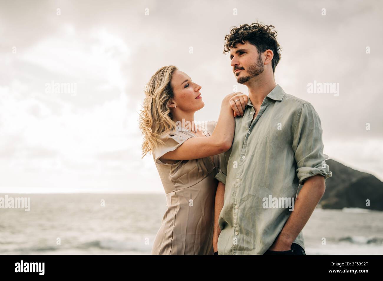 Jeune couple romantique debout ensemble au bord de l'océan Banque D'Images