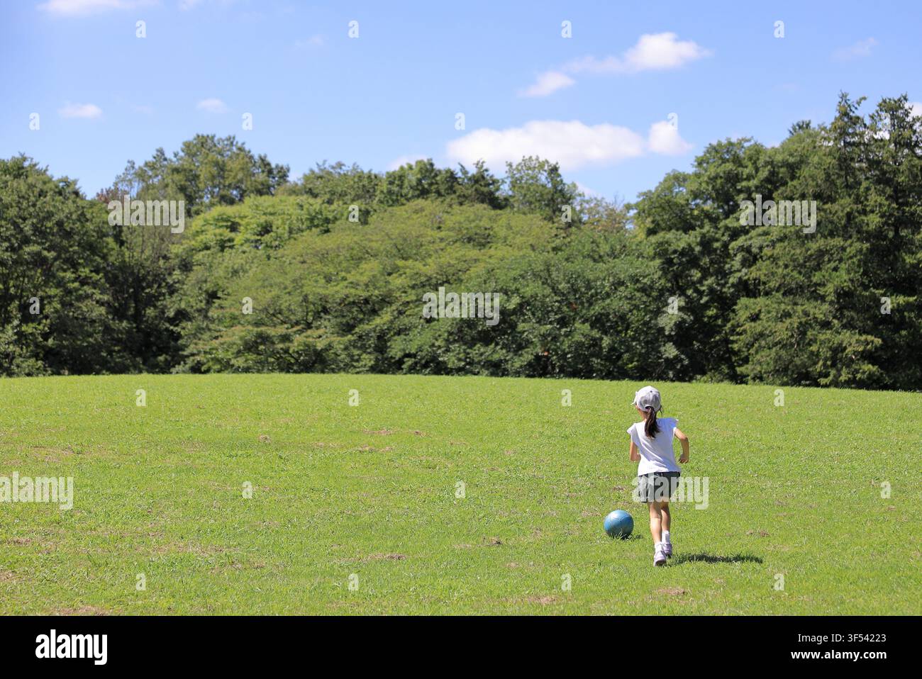 Élève japonaise jouant au football sur l'herbe (6 ans) Banque D'Images