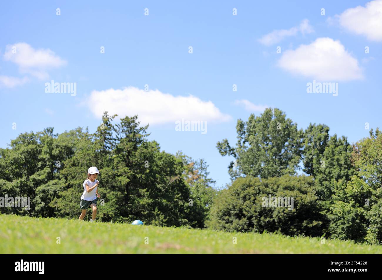 Élève japonaise jouant au football sur l'herbe (6 ans) Banque D'Images