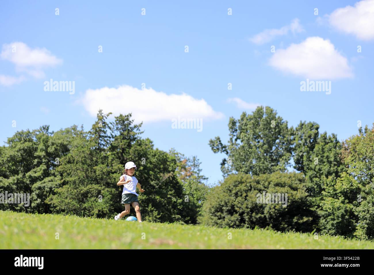 Élève japonaise jouant au football sur l'herbe (6 ans) Banque D'Images
