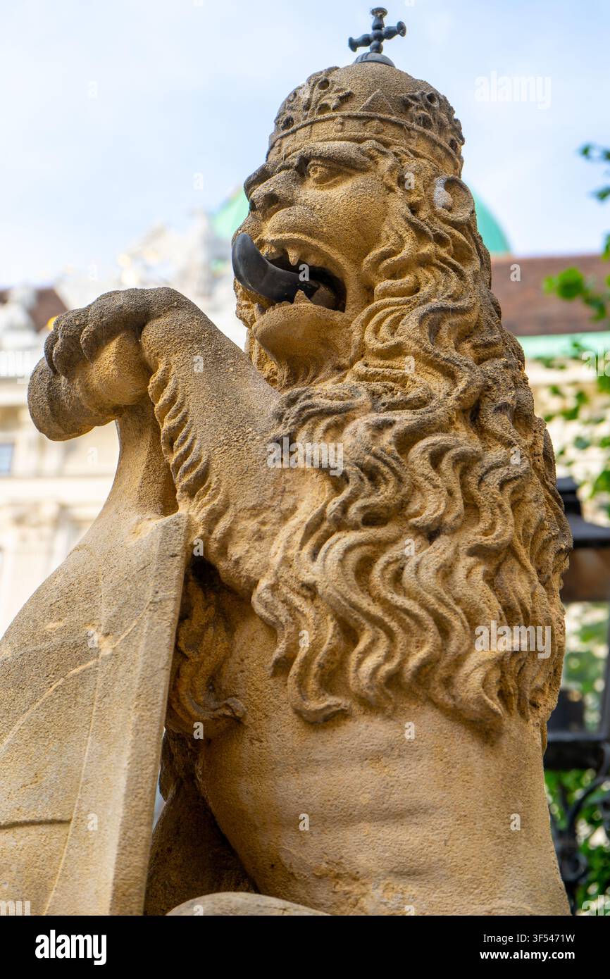 Statue de lion couronné de pierre avec bouclier près du bâtiment du palais impérial de Hofburg à Vienne, Autriche. Banque D'Images