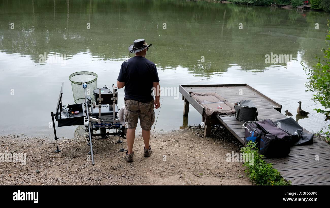 Homme pêchant avec un équipement high-tech dans un bassin à Shropshire, en Angleterre, en Grande-Bretagne, au Royaume-Uni Banque D'Images