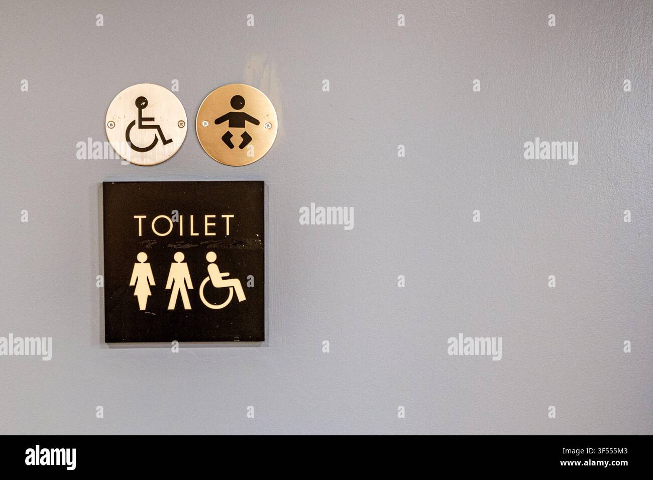Londres UK, 31 juillet 2026, Un gros plan d'une porte de toilettes accessibles peinte en gris avec un avis informel et des pictogrammes universels Banque D'Images