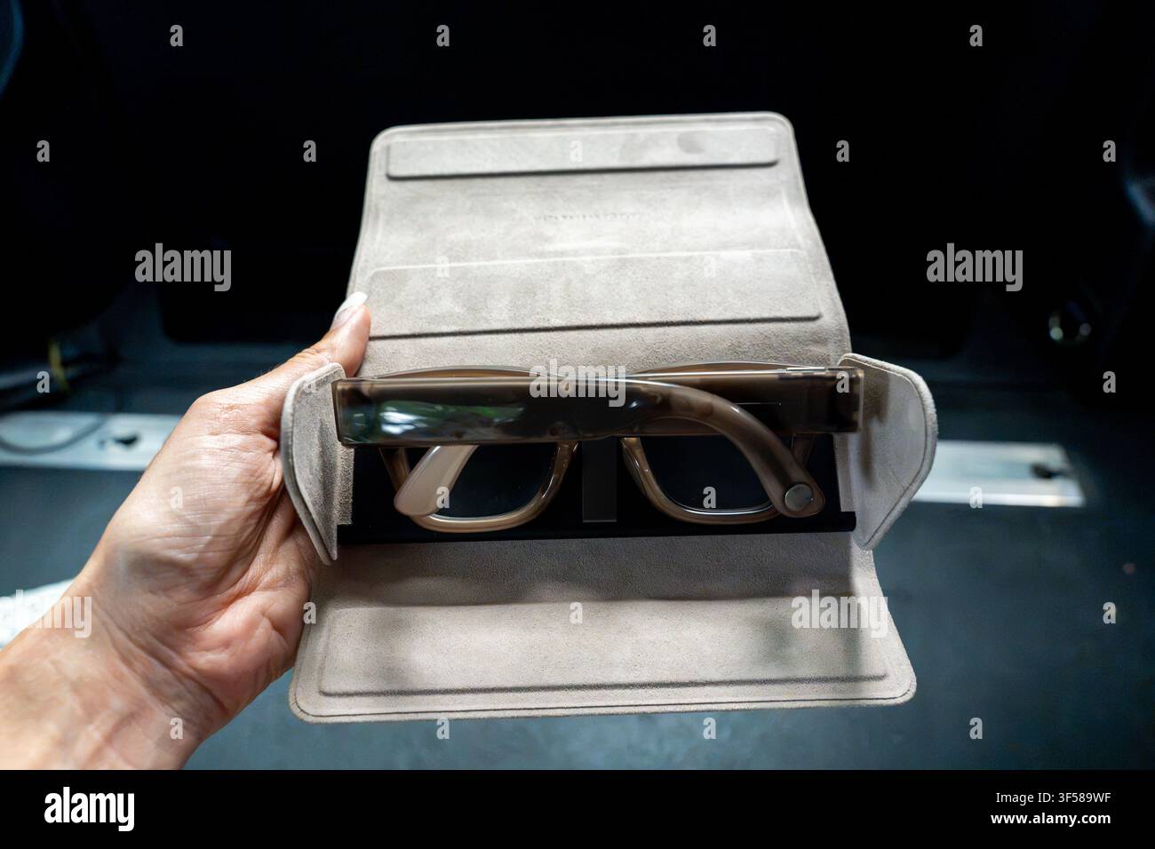Main tenant un étui de charge avec des lunettes intelligentes. Concept de technologie portable, de charge portable, de lunettes intelligentes et de style de vie numérique moderne Banque D'Images