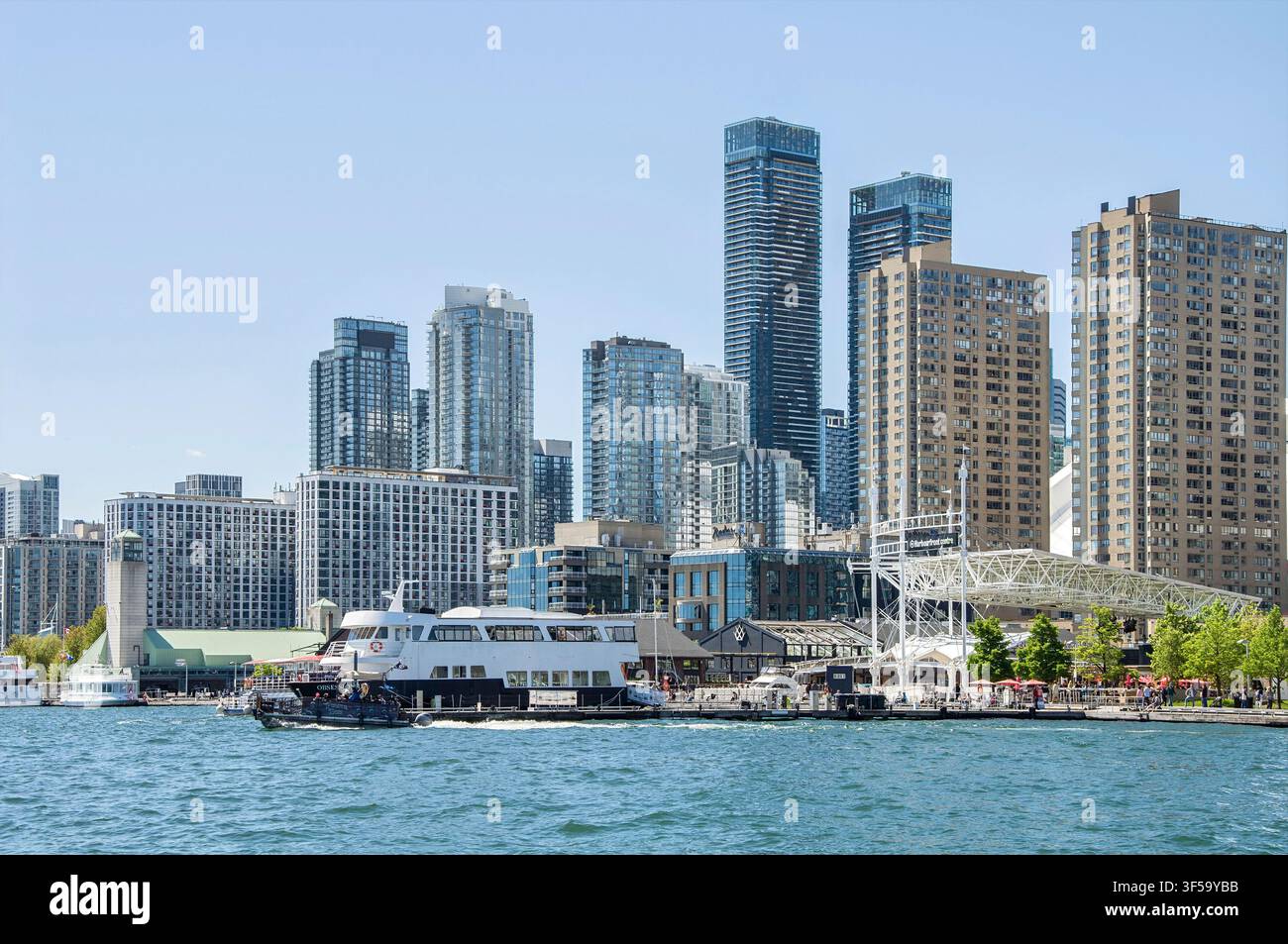 TORONTO, ONTARIO, CANADA - 30 MAI 2026 : Silhouette urbaine du centre-ville de Toronto avec des gratte-ciel modernes et un bateau-ferry touristique sur le lac Ontario près de Canada Place. Banque D'Images