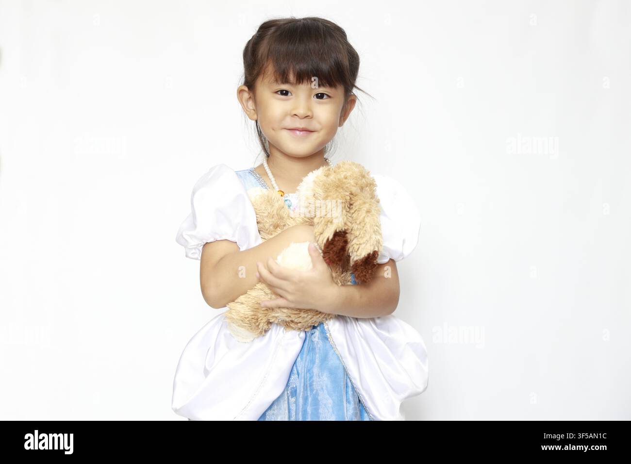 Jeune fille japonaise en robe tenant un lapin en peluche (4 ans) Banque D'Images