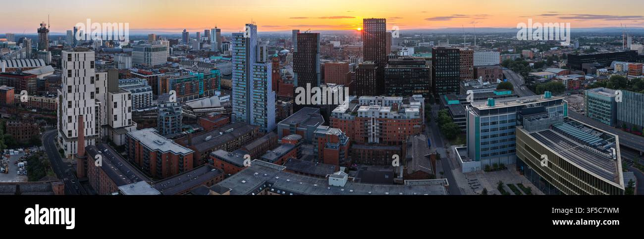 Panoramique d'un lever de soleil doré sur la skyline de Manchester et l'horizon des gratte-ciel modernes Banque D'Images