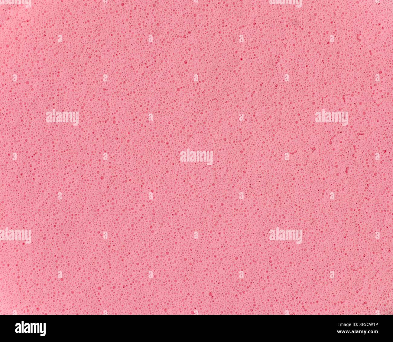 arrière-plan en texture d'éponge rose clair, surface en mousse poreuse avec de minuscules bulles et trous, vue macro en gros plan, matériau de nettoyage abstrait Banque D'Images