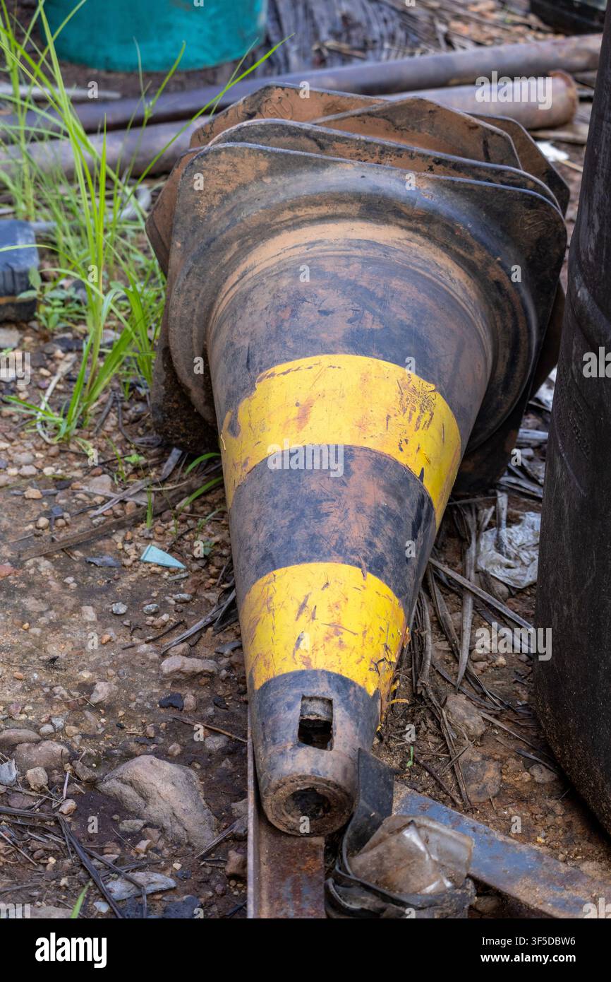 Un vieux cône abandonné au sol, autrefois utilisé pour la protection, pollue désormais l'environnement dans la forêt amazonienne, au Brésil. Banque D'Images