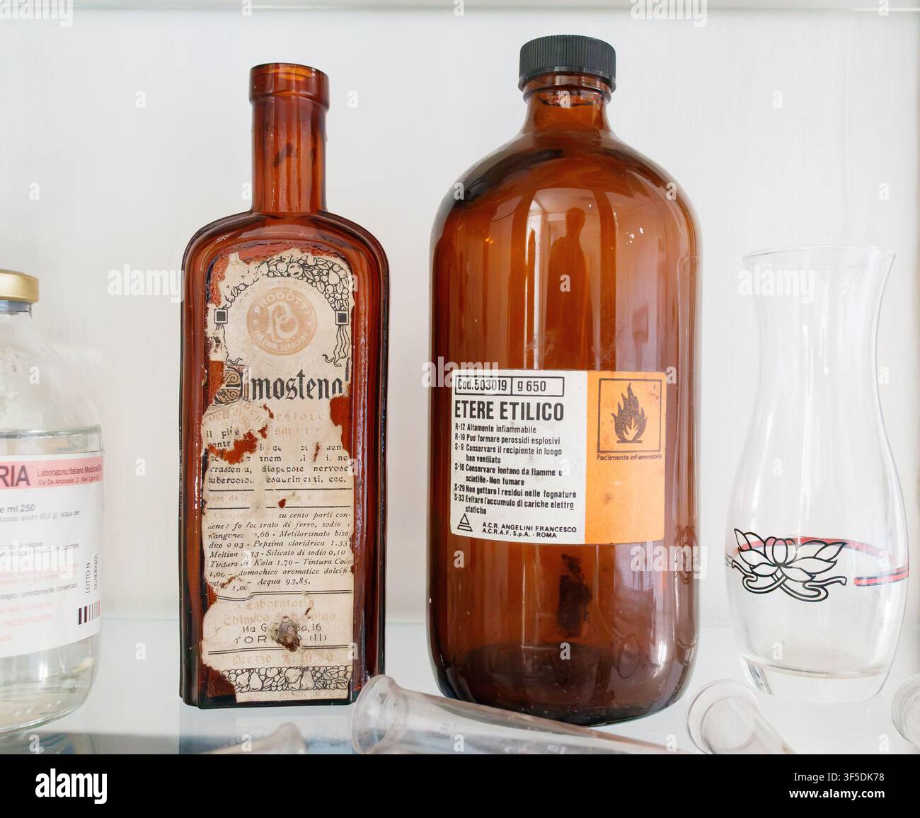 Bouteilles de pharmacie en verre ambré étiquetées Etere Etilico & Imosteno avec des seringues en verre par ACRAF S.p.A. Roma Banque D'Images