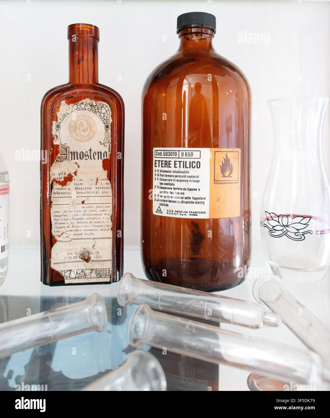 Bouteilles de pharmacie en verre ambré étiquetées Etere Etilico & Imosteno avec des seringues en verre par ACRAF S.p.A. Roma Banque D'Images
