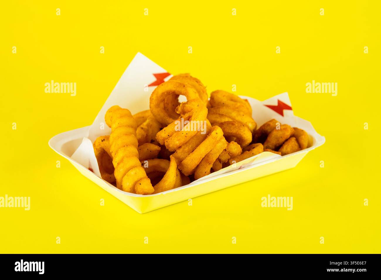 Pommes frisées croustillantes et snacks frits dans un plateau de fast-food sur fond jaune Banque D'Images