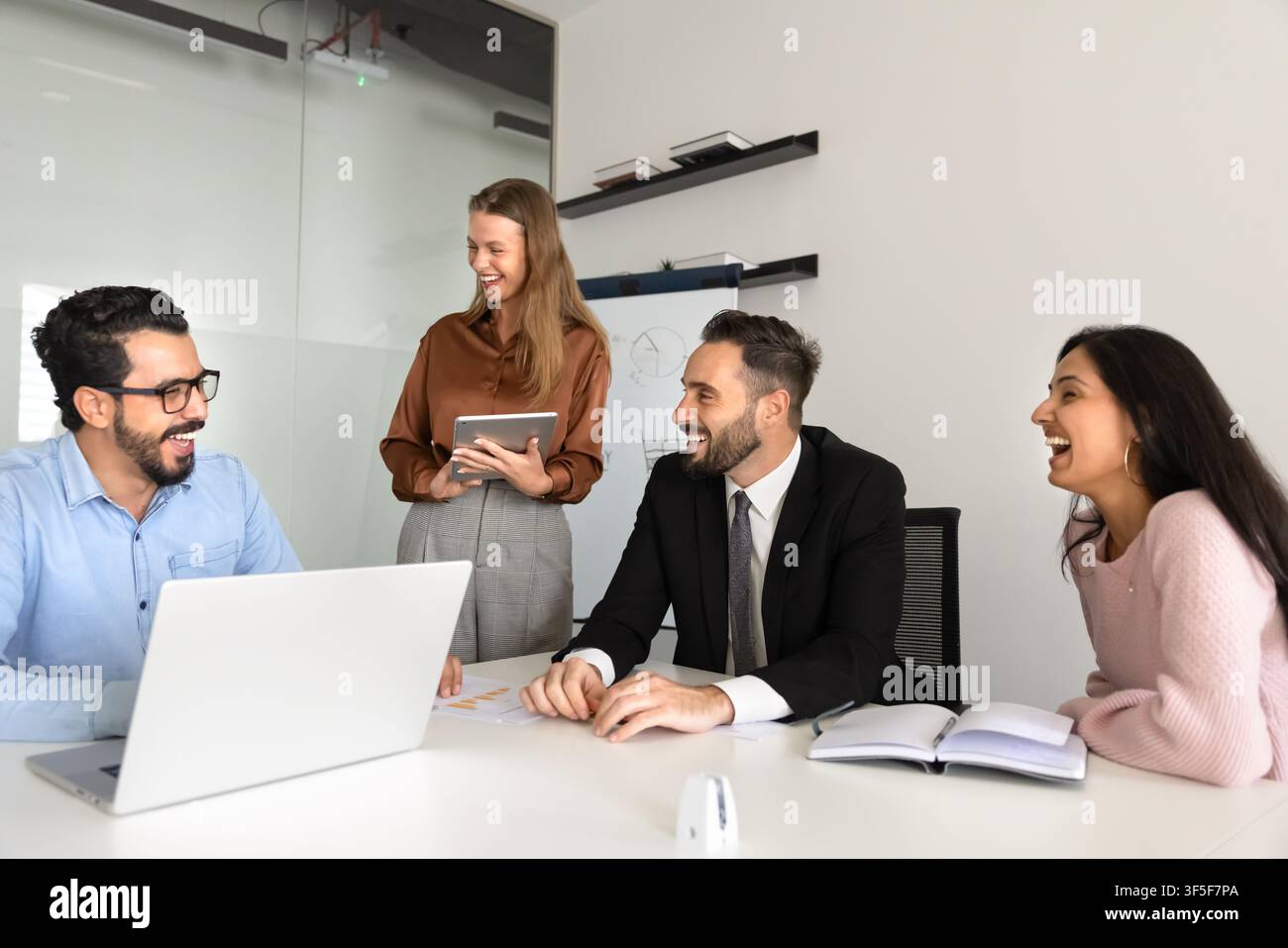 Groupe de membres d'une équipe professionnelle multiethnique riant pendant une discussion Banque D'Images