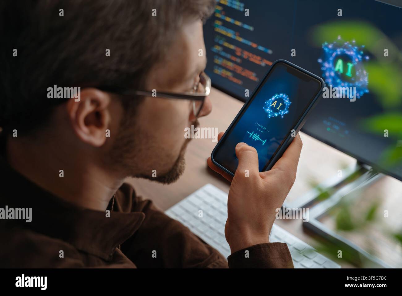 Gros plan d'un homme tenant un smartphone parlant à un assistant vocal personnel alimenté par l'IA utilisant l'intelligence artificielle sur le téléphone et l'ordinateur, interagissant avec une application de chatbot IA ou donnant des tâches à un agent IA.  Banque D'Images