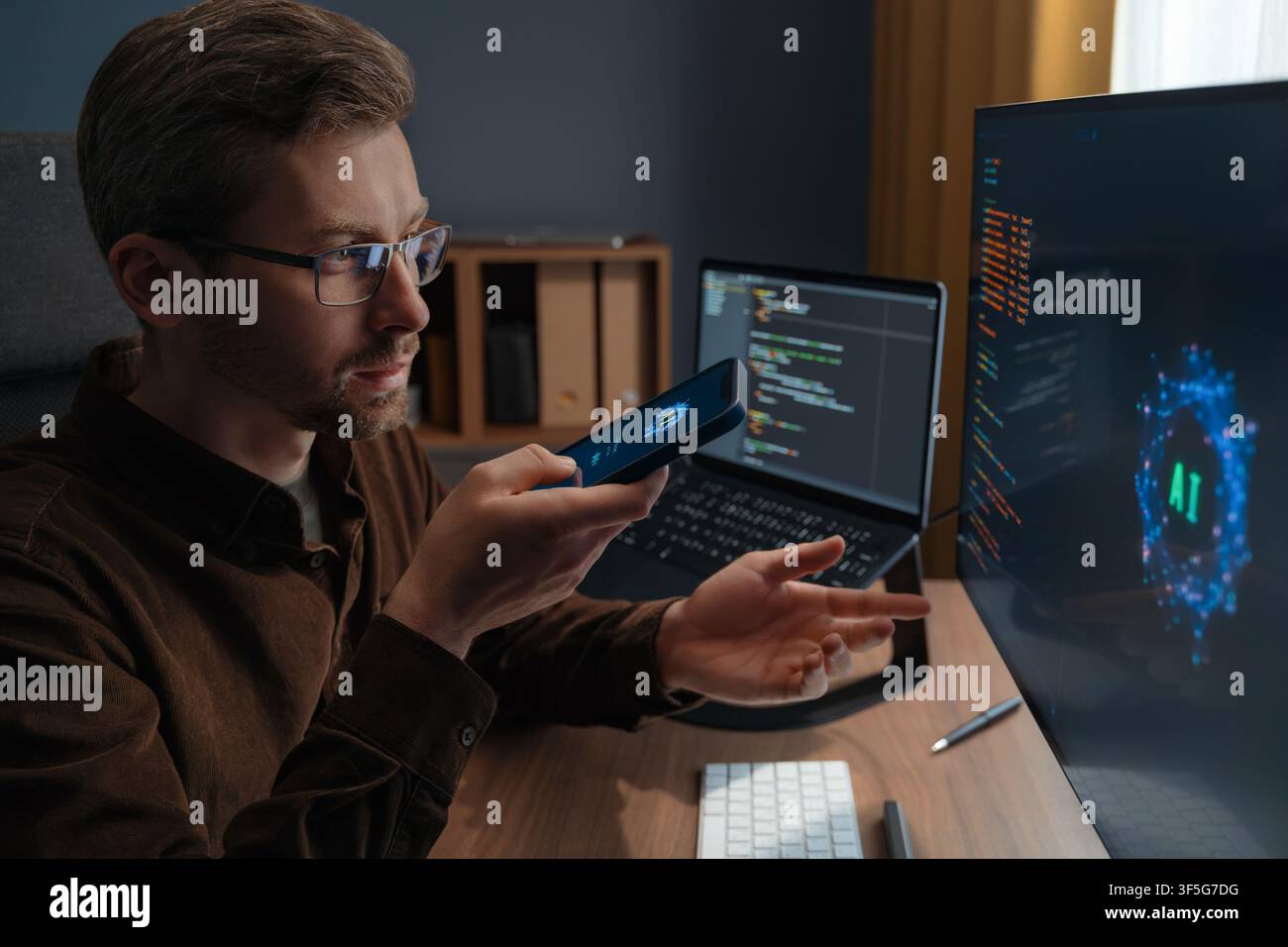 Gros plan d'un homme portant des lunettes parlant à un chatbot IA sur un smartphone tout en travaillant sur un ordinateur avec un agent d'intelligence artificielle. Homme utilisant un assistant d'intelligence artificielle pour le travail. Banque D'Images