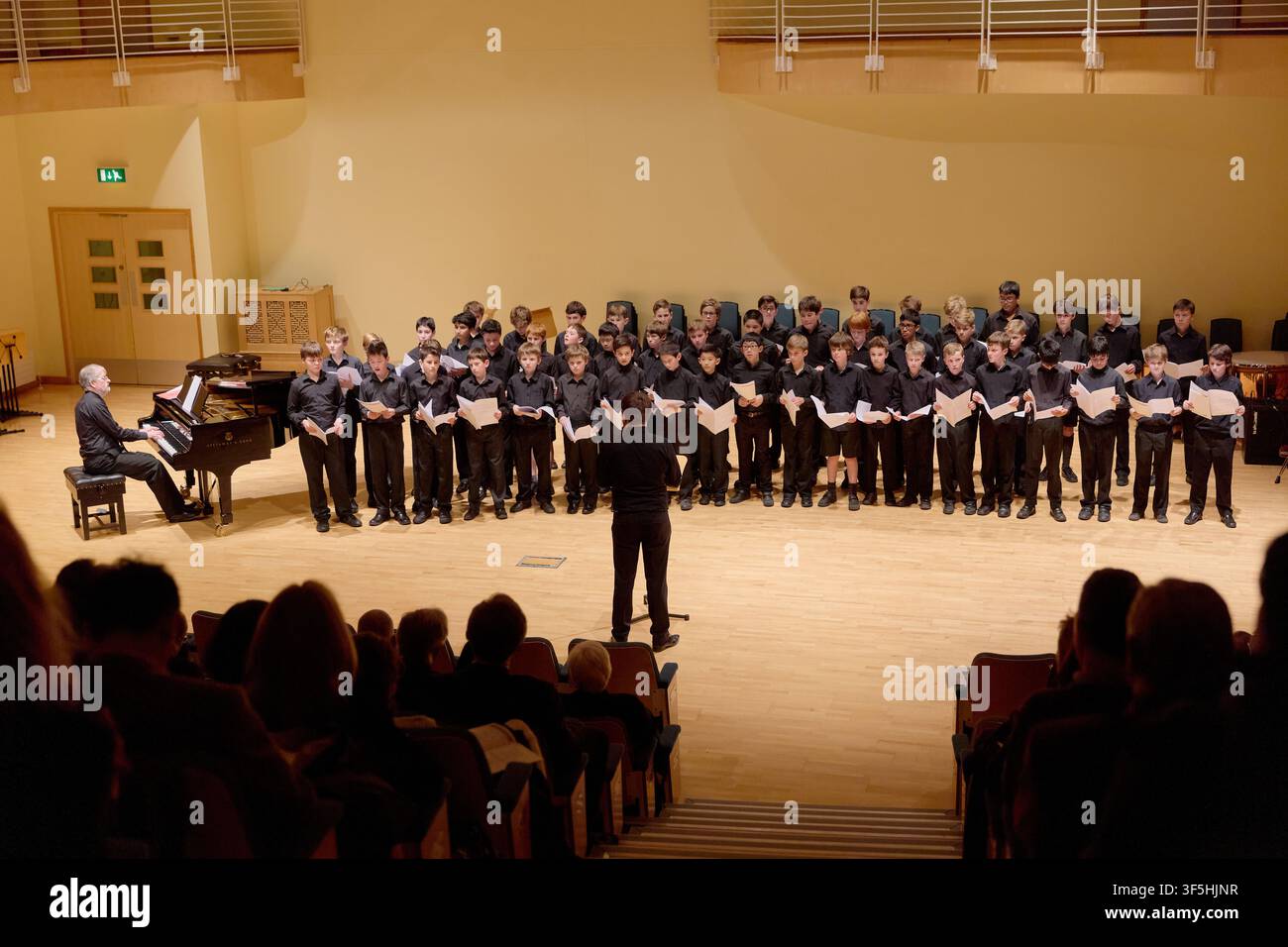 Un chœur se produit avec un pianiste et un chef d'orchestre lors d'un concert commémoratif à la Wathen Hall de la St Paul's School à Londres, en Angleterre, le 1er avril 2017. Banque D'Images
