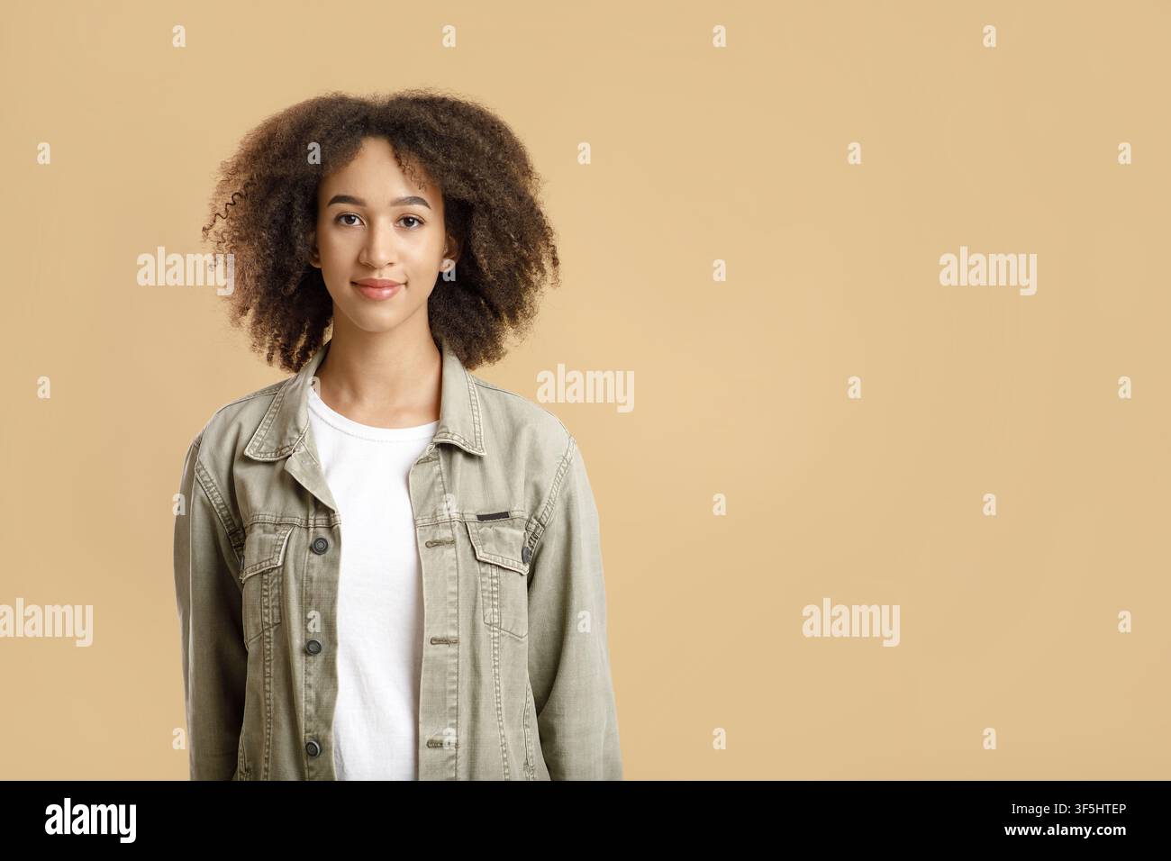 Mignonne femme afro-américaine bouclée dans le décontracté, se sentant heureuse et insouciante Banque D'Images