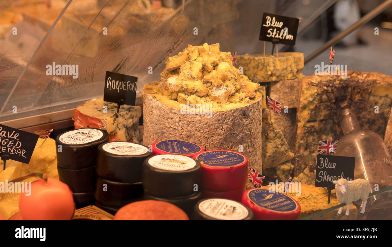 Fromages bleus britanniques et français avec étiquettes en tableau noir et drapeaux Union Jack dans une vitrine de charcuterie au Mercado do Bolhão, Porto, Portugal Banque D'Images