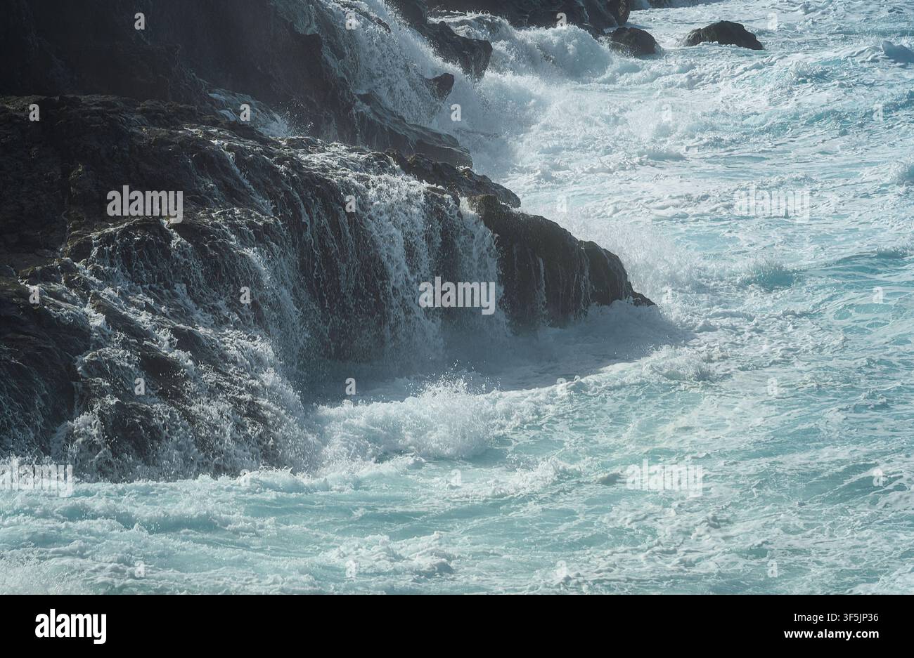 Puissantes vagues de l'océan Atlantique déferlant sur des rochers volcaniques abrupts sur la côte de Lanzarote, îles Canaries, Espagne. Banque D'Images