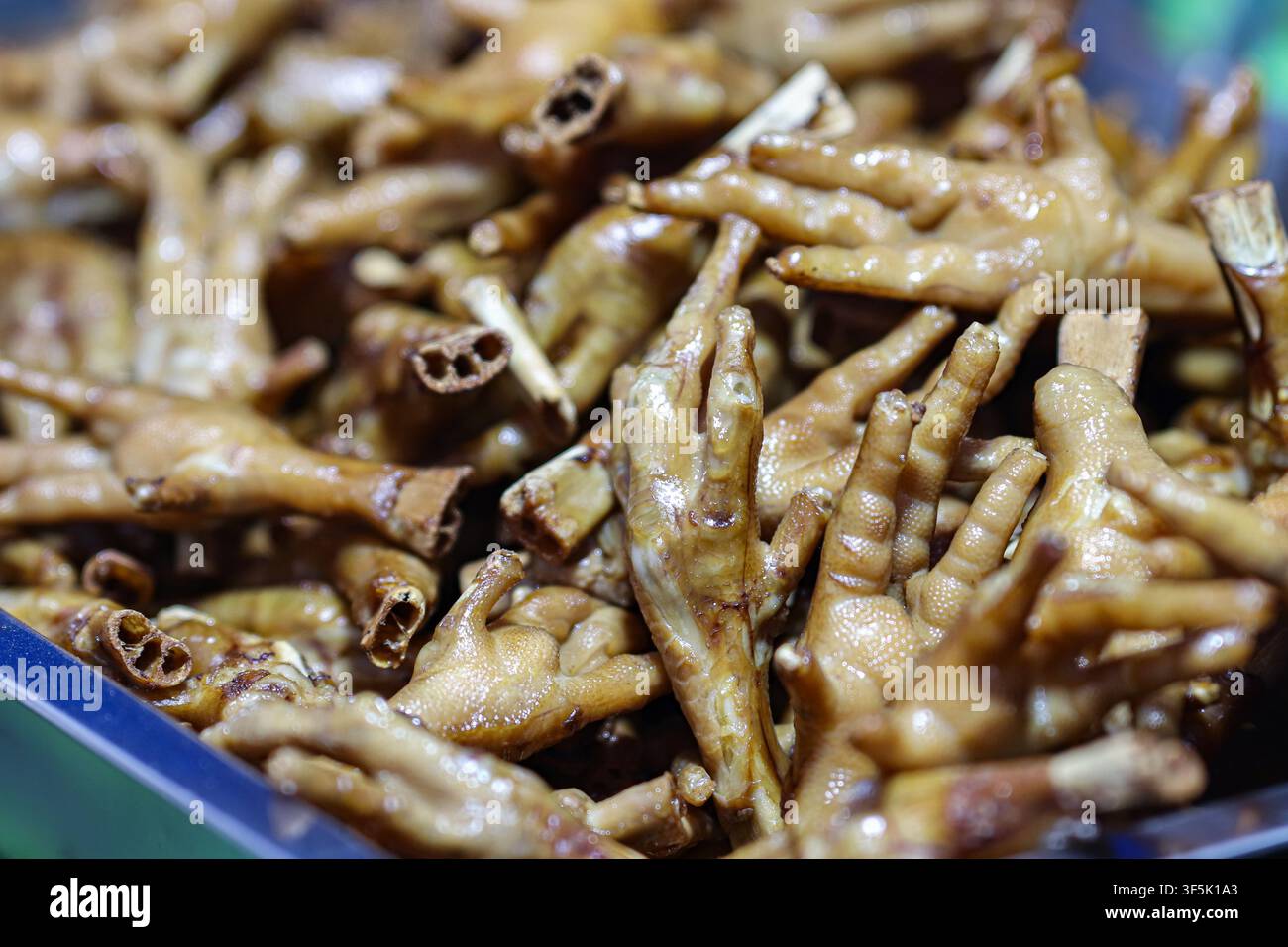 Pieds de poulet braisés avec sauce soja exposés sur un marché de rue thaïlandais traditionnel, illustrant une cuisine locale authentique et des repas de marché Banque D'Images