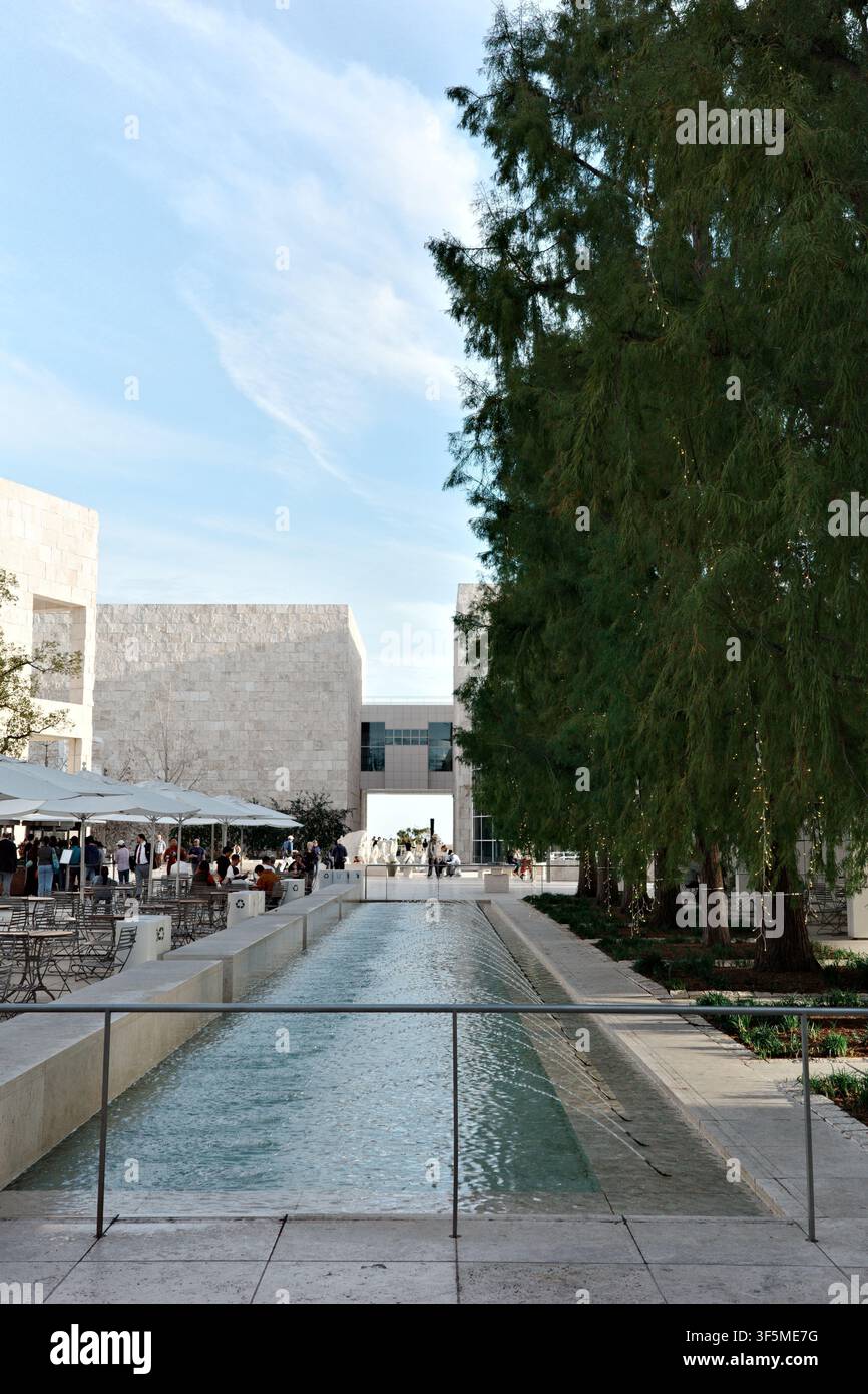 Bassins réfléchissants symétriques menant vers une arche en pierre au Getty Center, encadrés par des cyprès, Los Angeles Banque D'Images