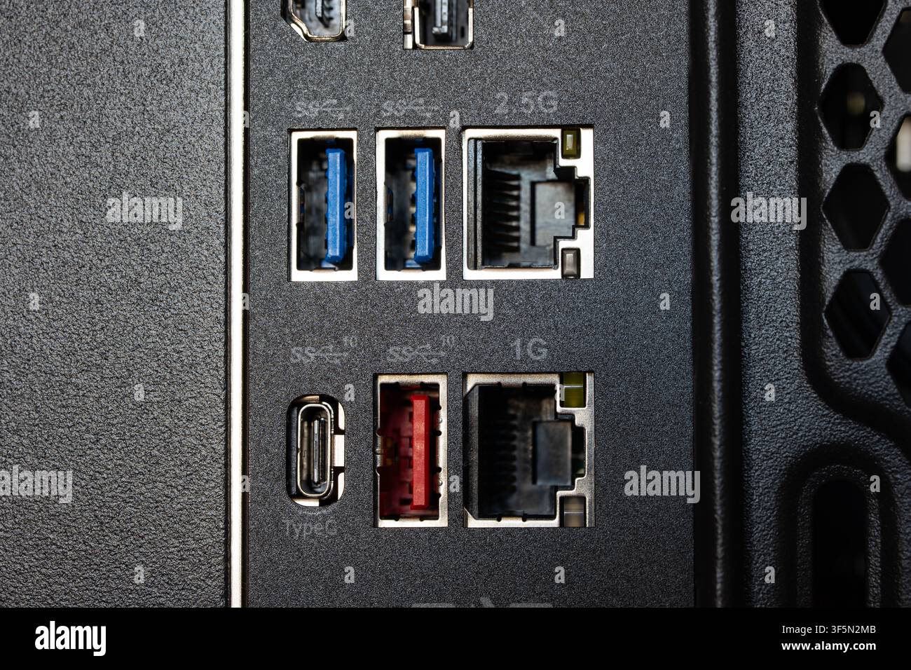 Grossissement macro du panneau IO arrière d'un carte mère d'ordinateur montrant des ports USB 3.0 bleus, un port USB rouge, un port Type-C ainsi que des connectiques Ethernet RJ45 1G et 2,5G Banque D'Images