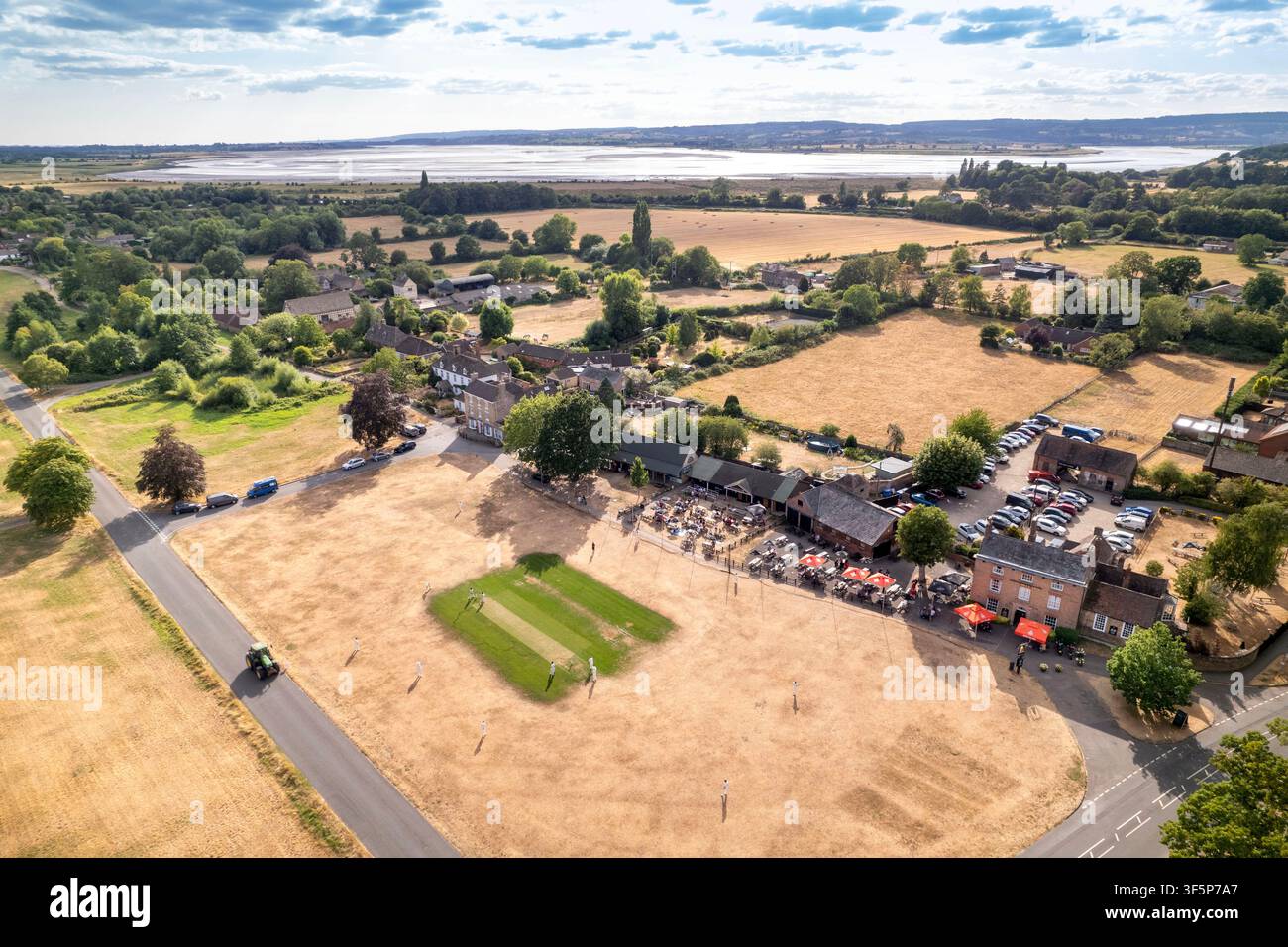 Le contraste frappant entre les wickets de cricket irrigués et le champ extérieur desséché à Frampton on Severn, réputé être l'un des plus longs Banque D'Images