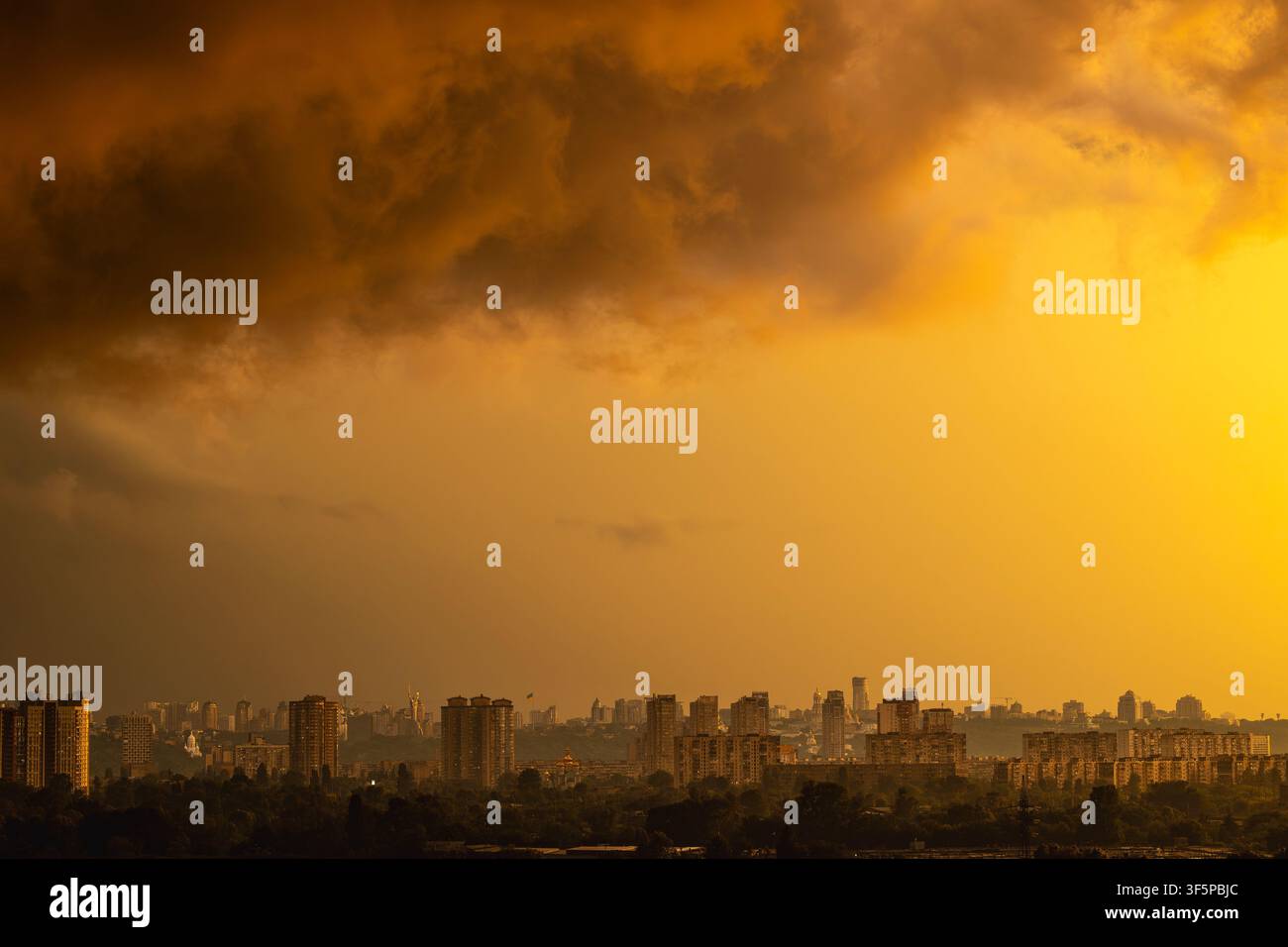 Kiev, vue panoramique de la ville ukrainienne surplombant la rivière Dnipro en direction du quartier de Pechersk avec des immeubles résidentiels imposants et une lumière dorée sous un ciel dramatique Banque D'Images