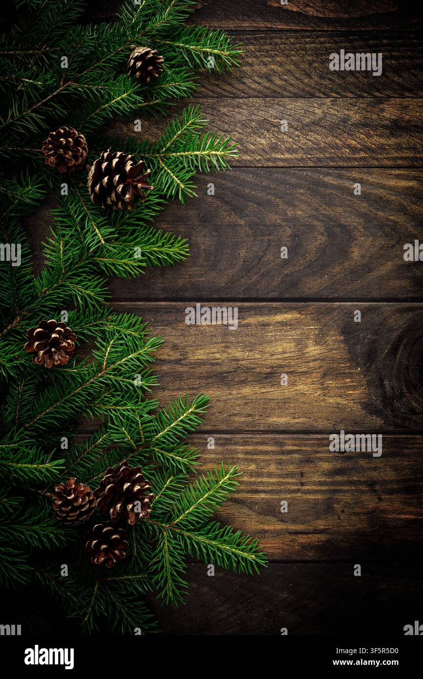 Fond de Noël avec des branches de sapin et des pommes de pin sur des planches en bois rustiques, décoration de Noël Banque D'Images