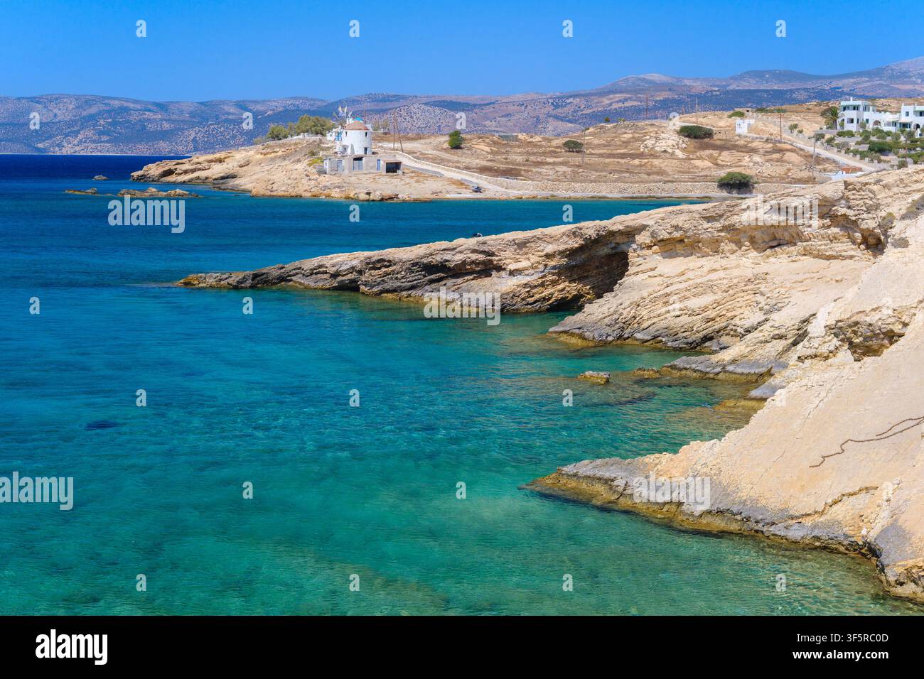 Bâtiments blanchis à la chaux sur une côte rocheuse avec une eau turquoise à Koufonisia, Grèce Banque D'Images