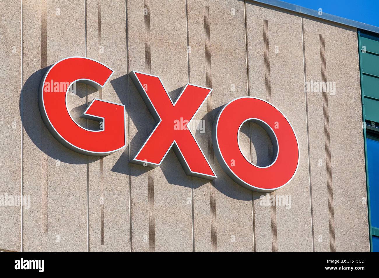 San Antonino, Ticino, Suisse – 3 juillet 2026 : Vue rapprochée du panneau du logo de l'entreprise GXO Logistics monté sur la façade en béton d'un entrepôt Banque D'Images