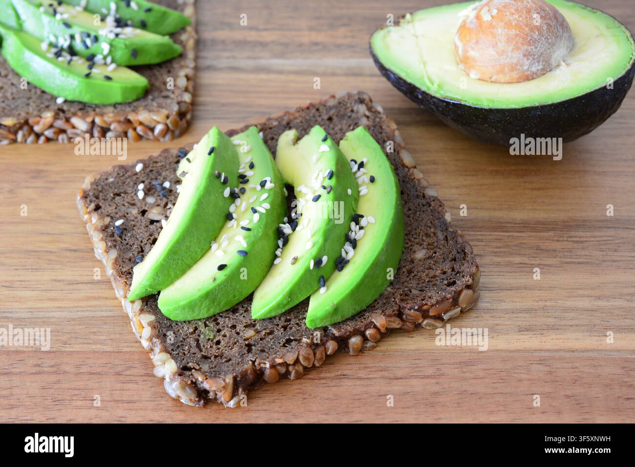 Toast à l'avocat avec graines de sésame sur table en bois gros plan Banque D'Images