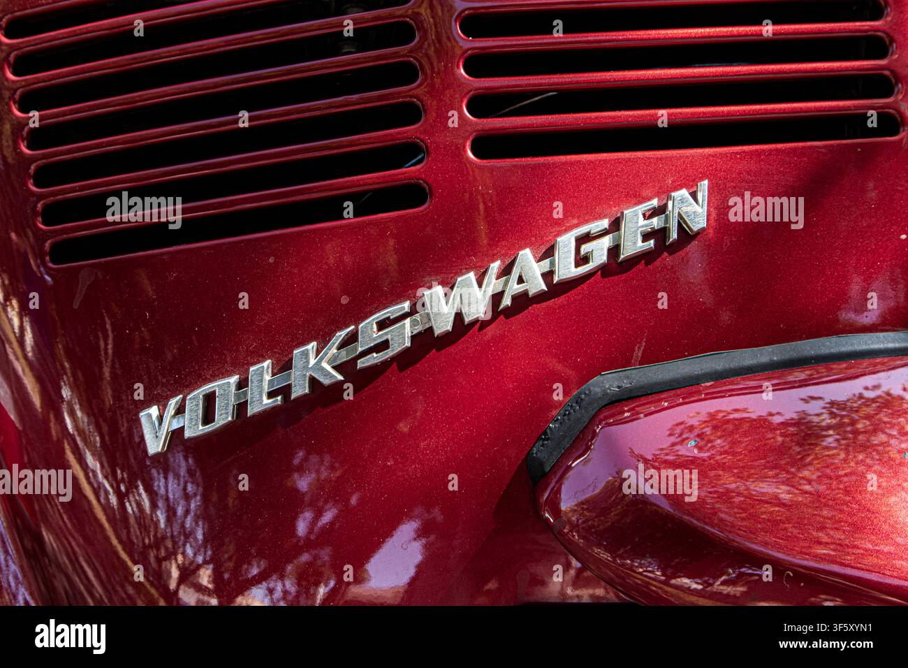 Tavernes Blanques, Espagne – 14 juin 2026. Cette prise met en évidence l'émblème chromé Volkswagen et la grille d'entrée d'air arrière d'une Coccinelle rouge classique. Th Banque D'Images