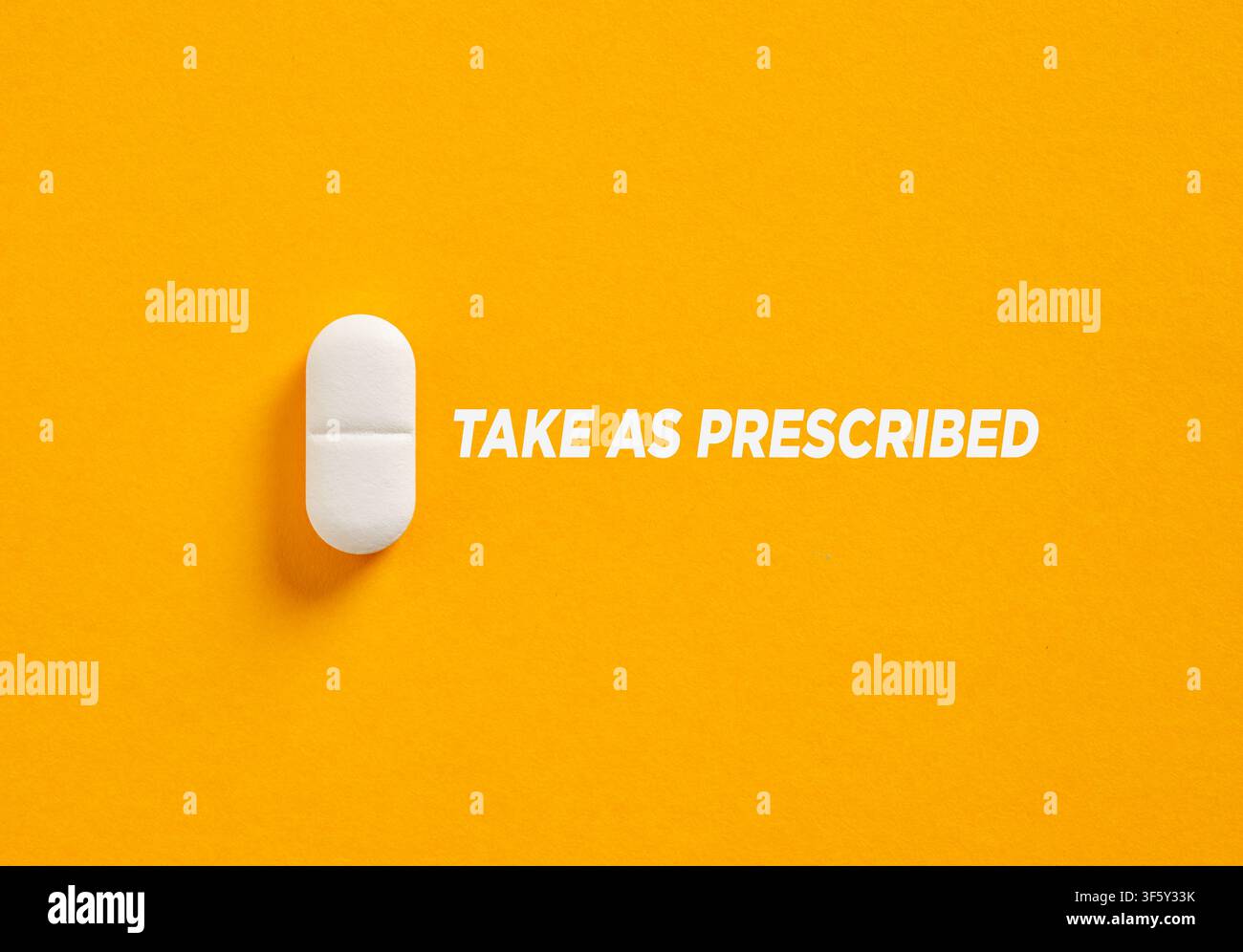 Une seule pilule blanche avec le mot "prendre comme prescrit" met l'accent sur l'importance d'une utilisation responsable des médicaments et de prendre la bonne dose. Banque D'Images