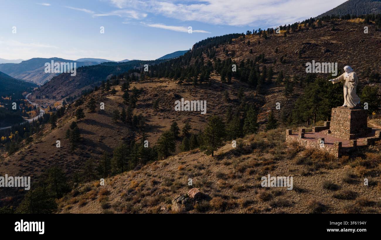 Vue aérienne de la statue du Christ des Rocheuses surplombant le paysage montagneux avec des pins et des routes sinueuses à Grant, Colorado, États-Unis. Banque D'Images