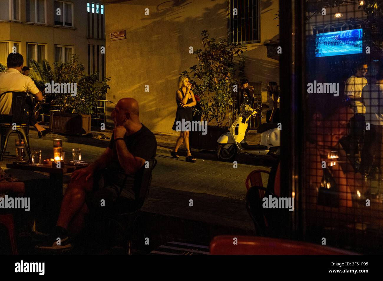 Istanbul, Turquie. 4 août 2026. Une femme fume une cigarette tandis que d’autres dînent dans un bar à Istanbul, Turquie. (Crédit image : © Moe Zoyari/ZUMA Press Wire) UTILISATION ÉDITORIALE UNIQUEMENT ! Pas pour une UTILISATION COMMERCIALE ! Banque D'Images