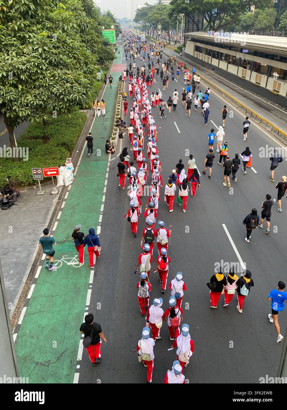 Les membres d'une fanfare scolaire défilent en formation le long de Jalan Jenderal Sudirman lors du jour sans voiture hebdomadaire de Jakarta - Image de stock capturée avec un smartphone