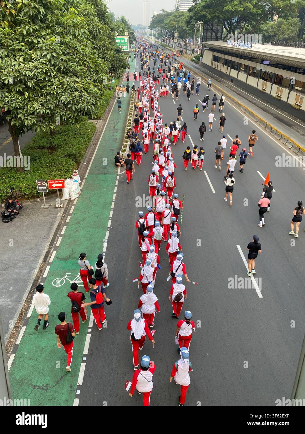 Les membres d'une fanfare scolaire défilent en formation le long de Jalan Jenderal Sudirman lors du jour sans voiture hebdomadaire de Jakarta - Image de stock capturée avec un smartphone