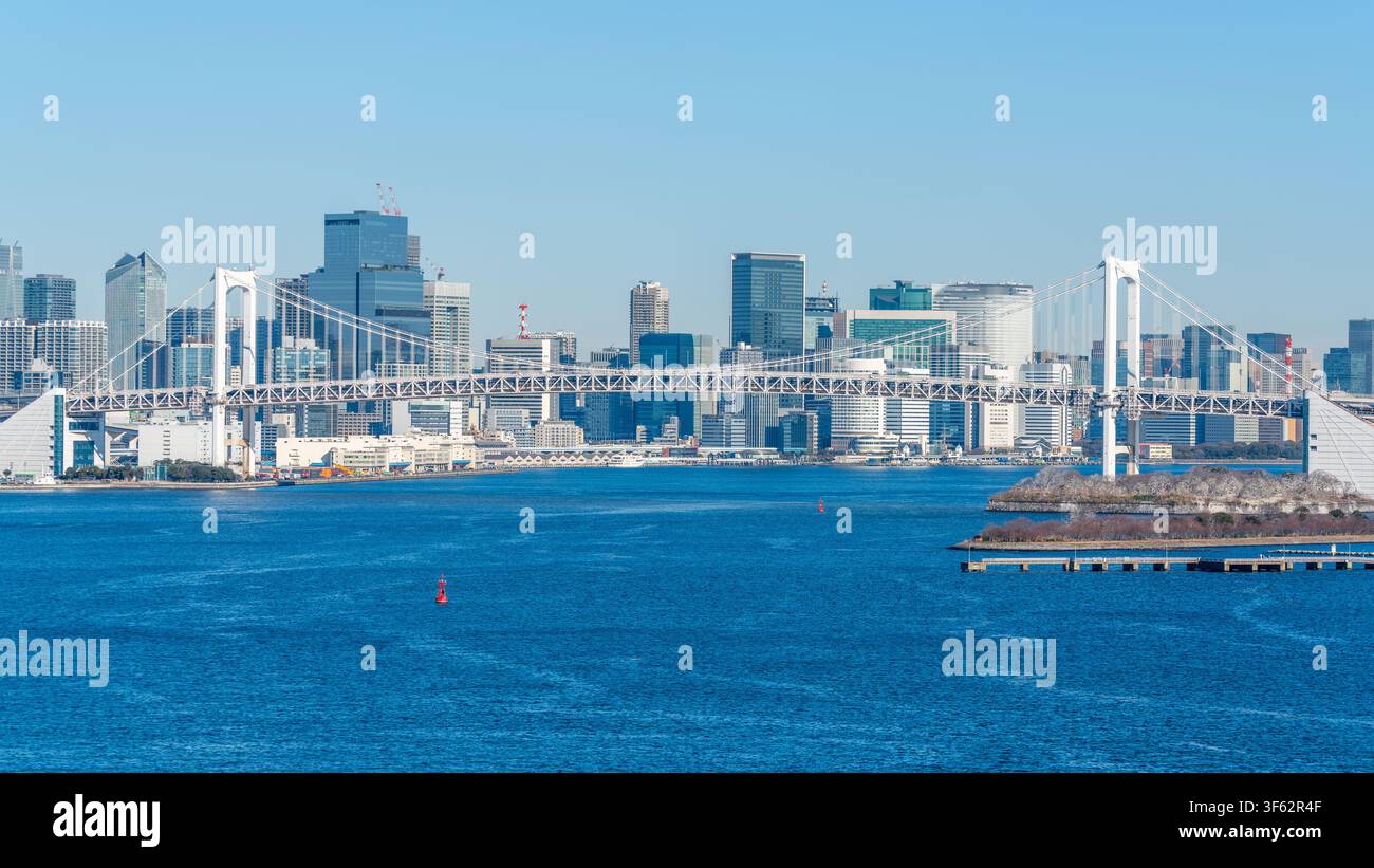 Rainbow Bridge, un pont suspendu au-dessus de la baie de Tokyo et l'horizon urbain avec un ciel bleu et la lumière du matin d'hiver à Tokyo, Japon Banque D'Images