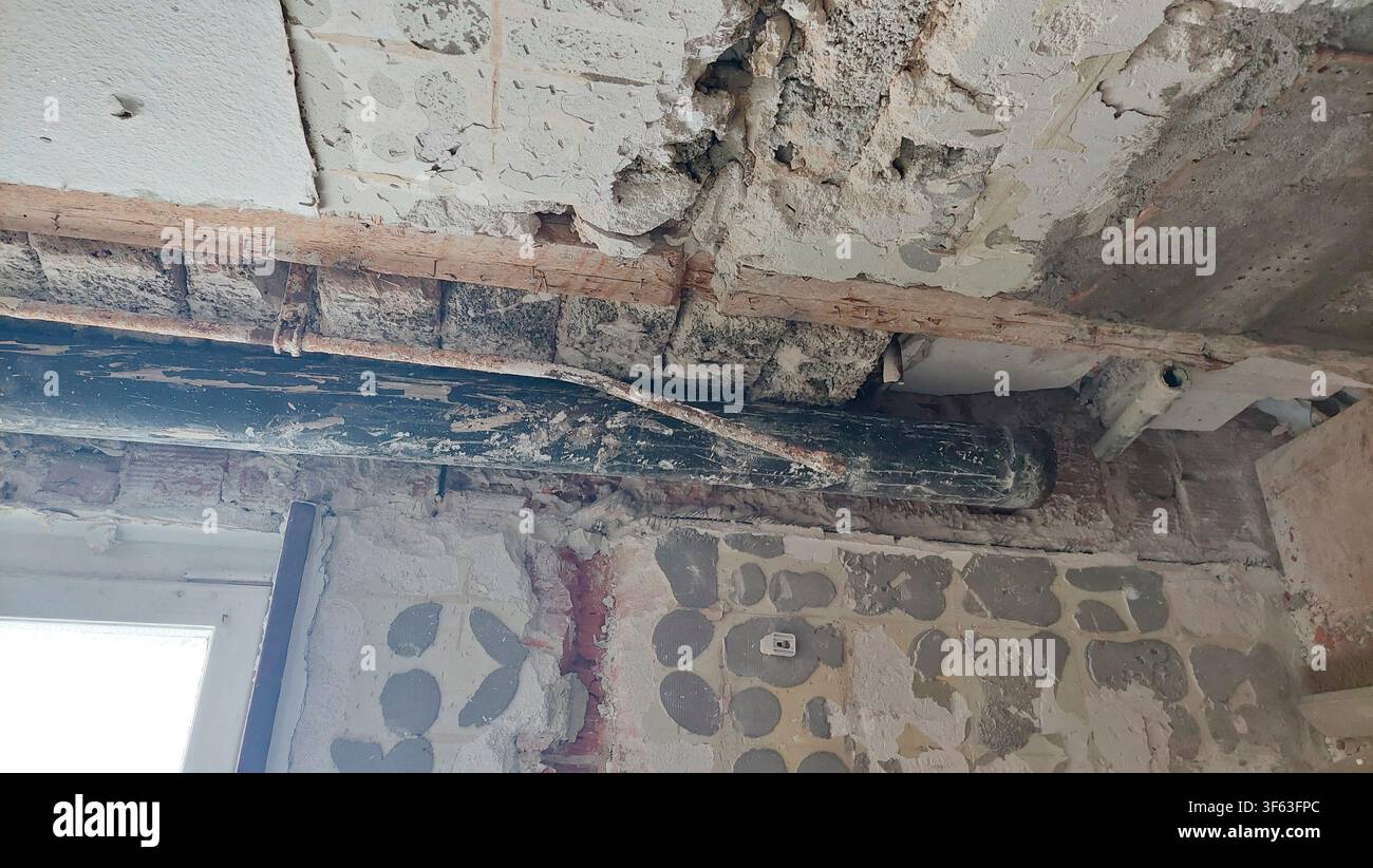 Rénovation majeure dans un bâtiment ancien : retrait du vieux tuyau d'égout en fonte Banque D'Images