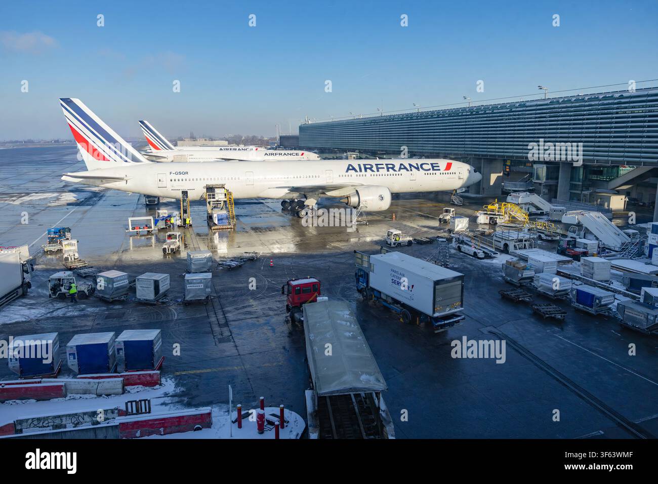 Paris, France - 5 juillet 2026 : avion de ligne Air France Boeing 777 en service au terminal de l'aéroport avec des véhicules de service au sol Banque D'Images