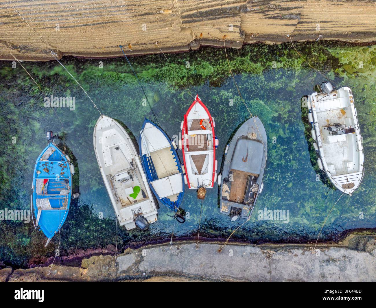 Vue aérienne des bateaux de pêche amarrés dans les eaux cristallines de Cala Porticciolo, Santa Cesarea Terme, province de Lecce, Pouilles, Italie Banque D'Images