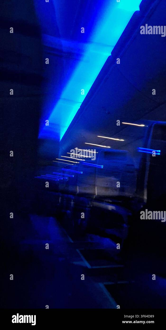 Vue abstraite d'un vol de nuit avec un éclairage d'ambiance bleu dans la cabine et des traînées de lumière Banque D'Images