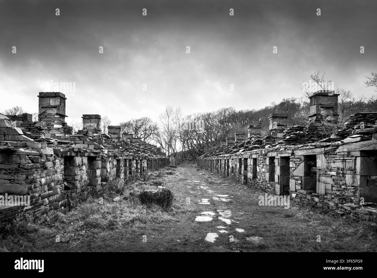 Photographie en noir et blanc des cottages en pierre d'ardoise des ruines des casernes d'Anglesey (Y Dre' Newydd) dans l'abandonnée carrière de Dinorwic, Nord du Pays de Galles. Banque D'Images