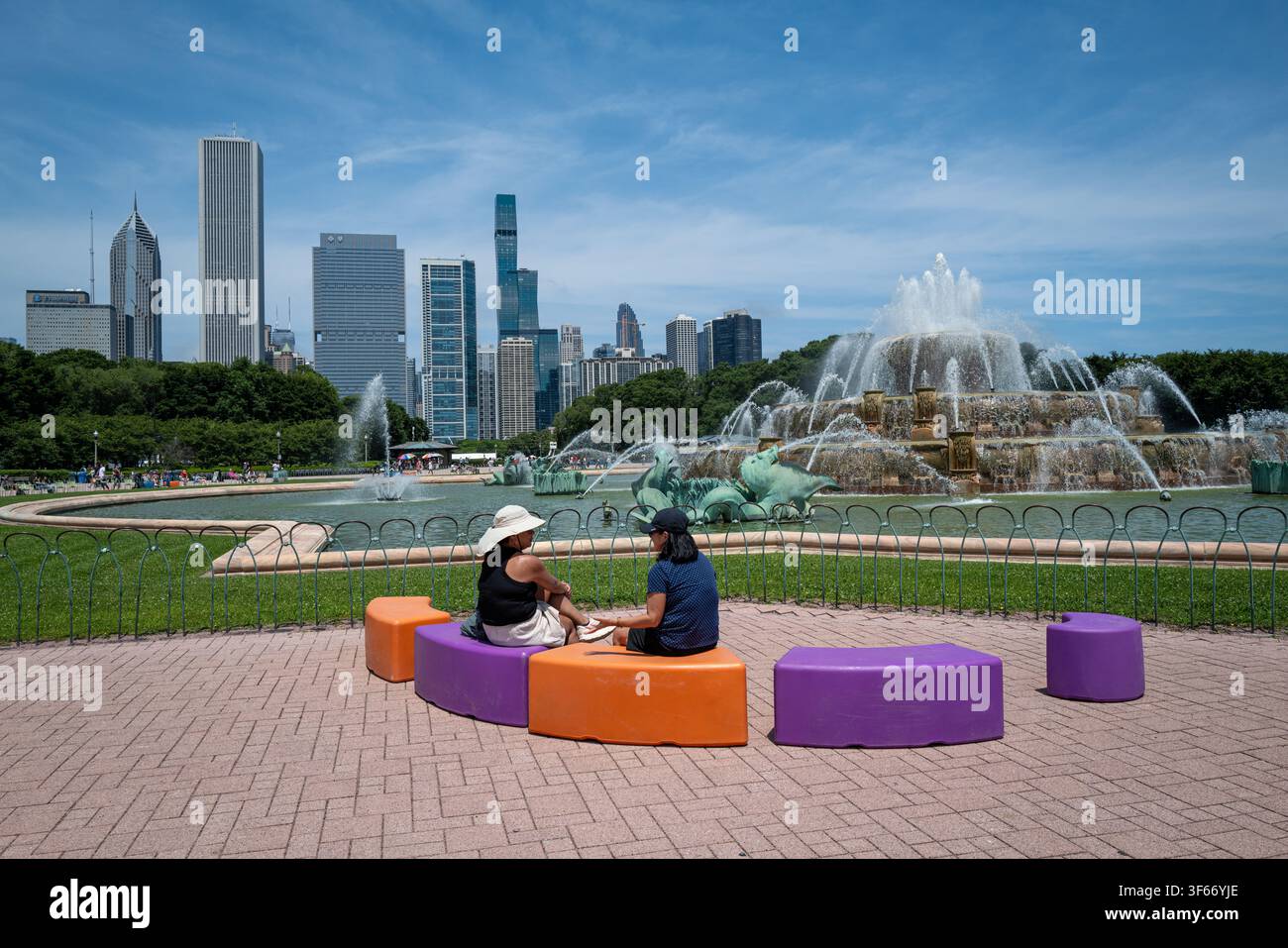 Fontaine Buckingham dans le Grant Park avec des gens se relaxant sur des sièges colorés et l'horizon du centre-ville en arrière-plan. Banque D'Images