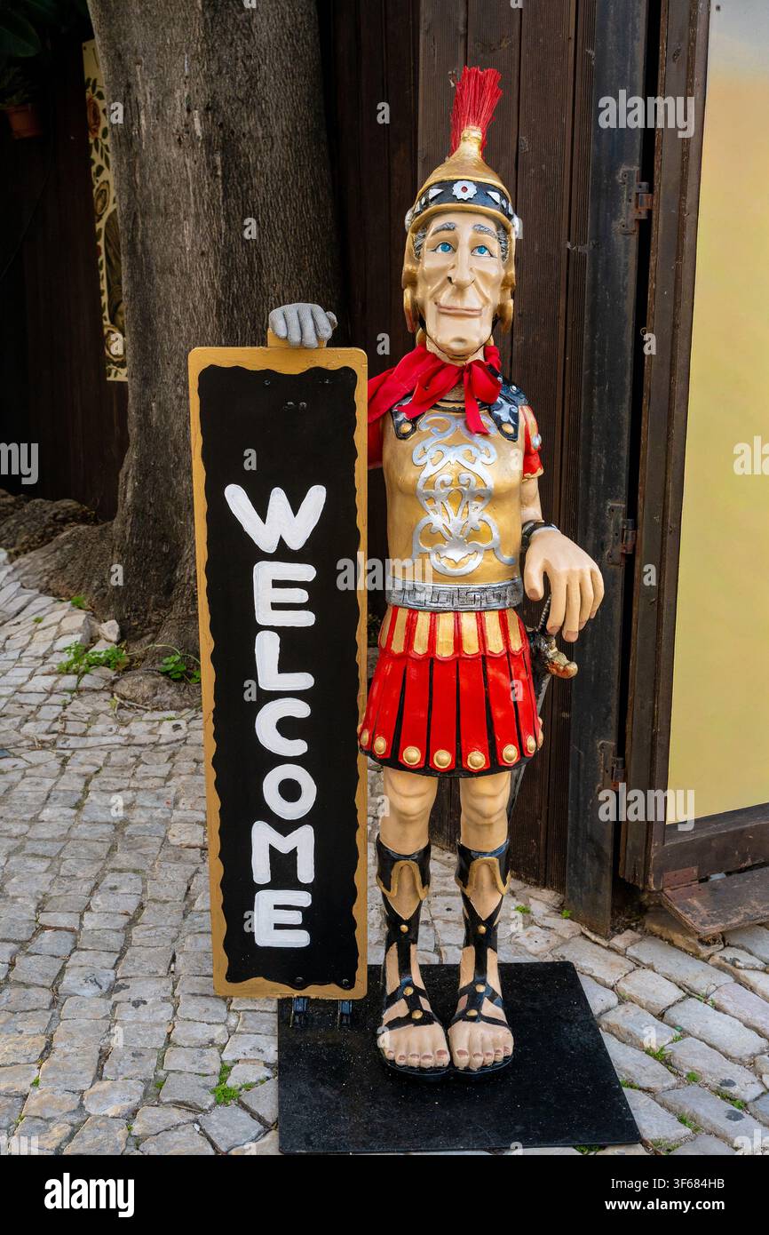 Figure en bois d'un soldat romain avec une enseigne WE:COME à l'extérieur d'un restaurant Banque D'Images
