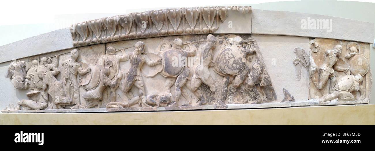 DELPHI, GRÈCE - 13 MAI 2025 - Bas-relief en marbre représentant des guerriers grecs musclés en combat, fragment architectural sculpté représentant le mil classique Banque D'Images